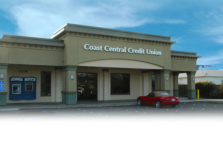 parking lot to building view of credit union offices with red car out front