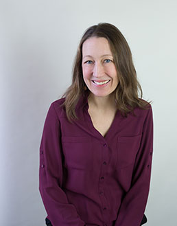 close up of smiling woman in burgundy colored blouse