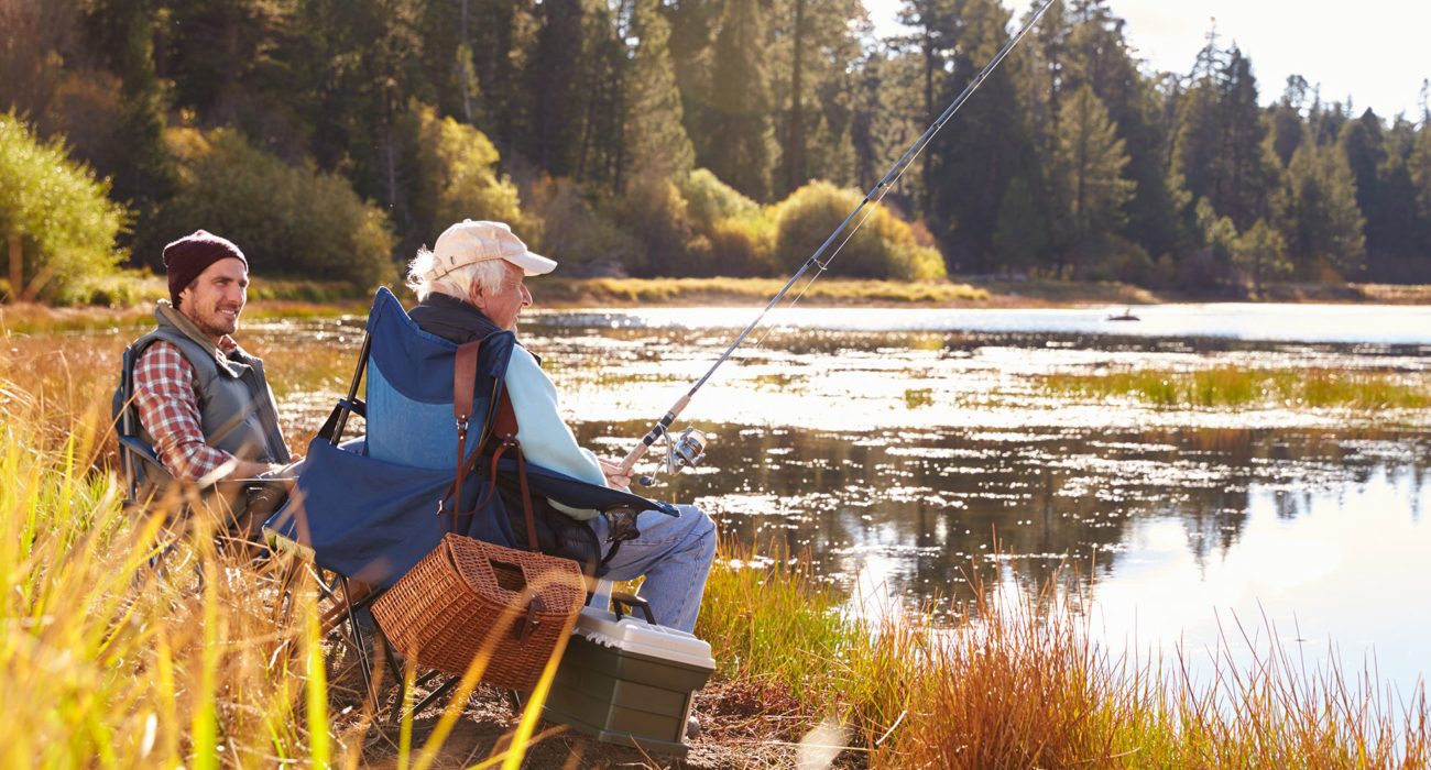 two men beside a river with fishing equipment
