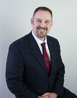 close up of smiling man in suit and tie