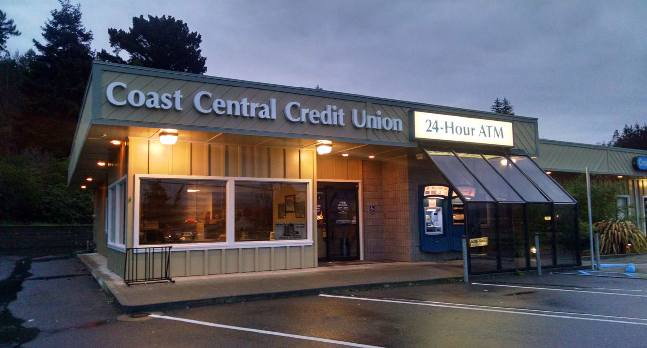 credit union building with lights on as night falls