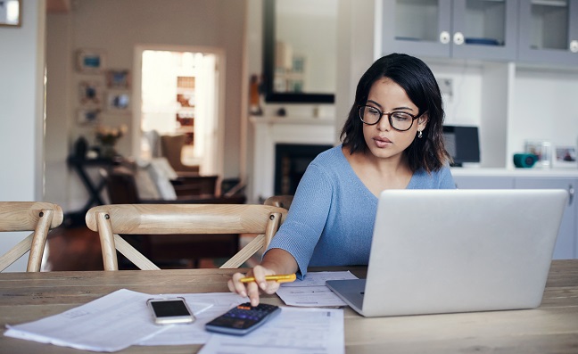 Young woman calculating her finances. Access our financial calculators to help you make informed decisions!