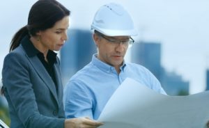 Businesswoman reviews construction plans with an engineer. We'll help you expand and grow your business!