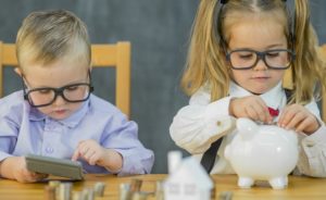 Two toddlers dressed as business casual accountants count their money.