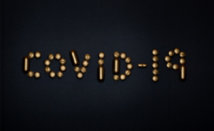 brown shapes spell out COVID-19 against a black background