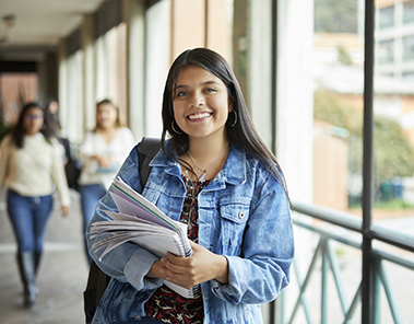 Photo of a smiling woman standing in corridor at university