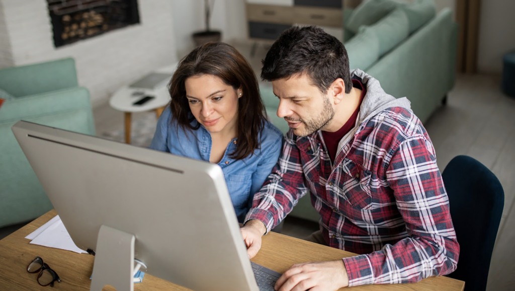 A man and a women working on a desktop computer
