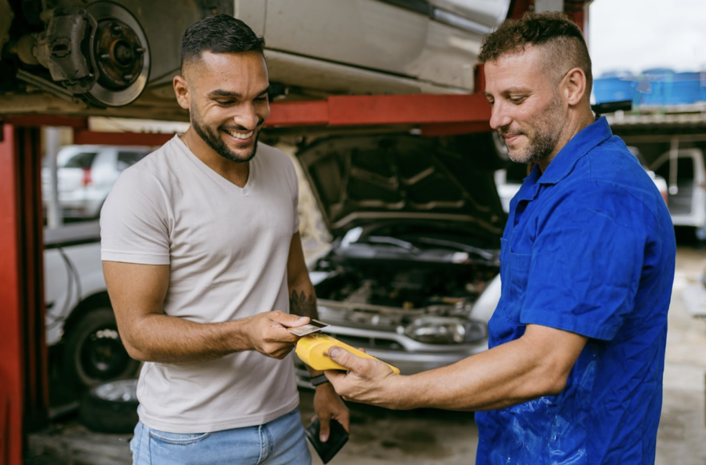 A man at a autobody shop paying for services