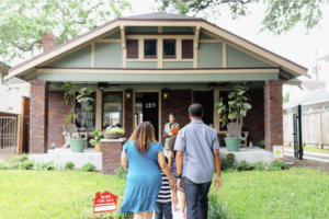 Young family viewing an open house with an agent while looking for a new home