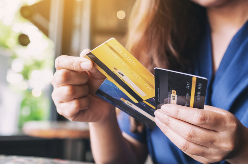 Girl holding three different credit cards in her hands